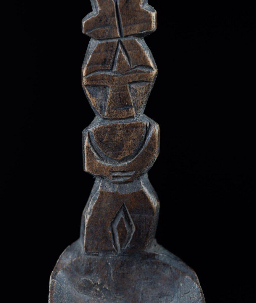 Old spoon from the Paiwan tribe, carved with two full-length standing figures, one above the other.