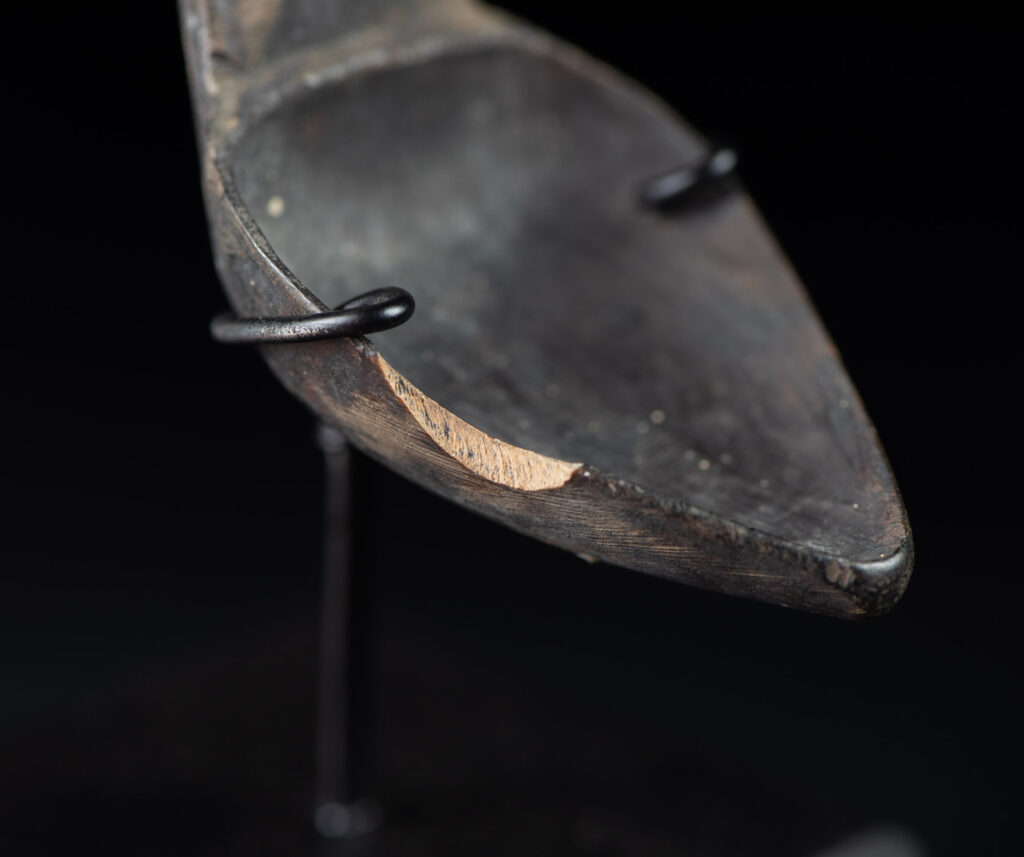Old wooden spoon from the Paiwan tribe, carved with a standing figure and a deer at its feet.