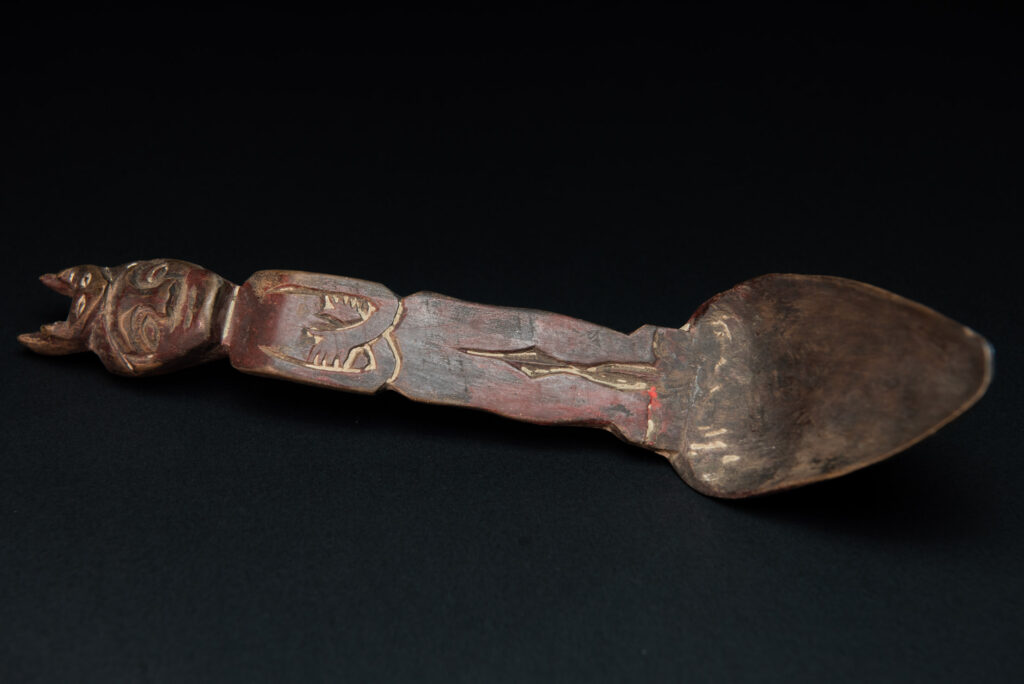 Old spoon from the Paiwan tribe, tinted with red pigments and depicting an ancestor wearing a ceremonial headdress.