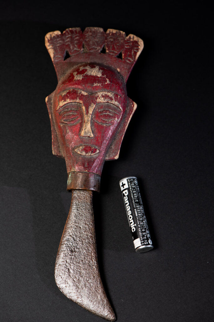 Small shamanic knife from the Paiwan tribe, intended for sacred rituals. Painted in red and carved with a human head surmounted by additional heads, it reflects the typical style of Paiwan shamans and healers, who are in charge of the tribe’s physical and spiritual well-being.