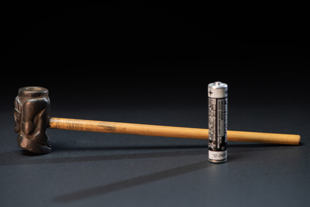 Very fine pipe made of precious wood from the Paiwan tribe, carved with human faces representing a Paiwan warrior and a stylised deer. The bottom is carved in a deer hoof shape.warrior and a stylised deer.