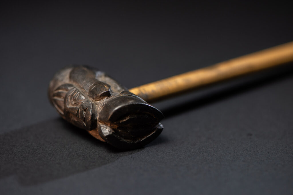 Very fine pipe made of precious wood from the Paiwan tribe, carved with human faces representing a Paiwan warrior and a stylised deer. The bottom is carved in a deer hoof shape.