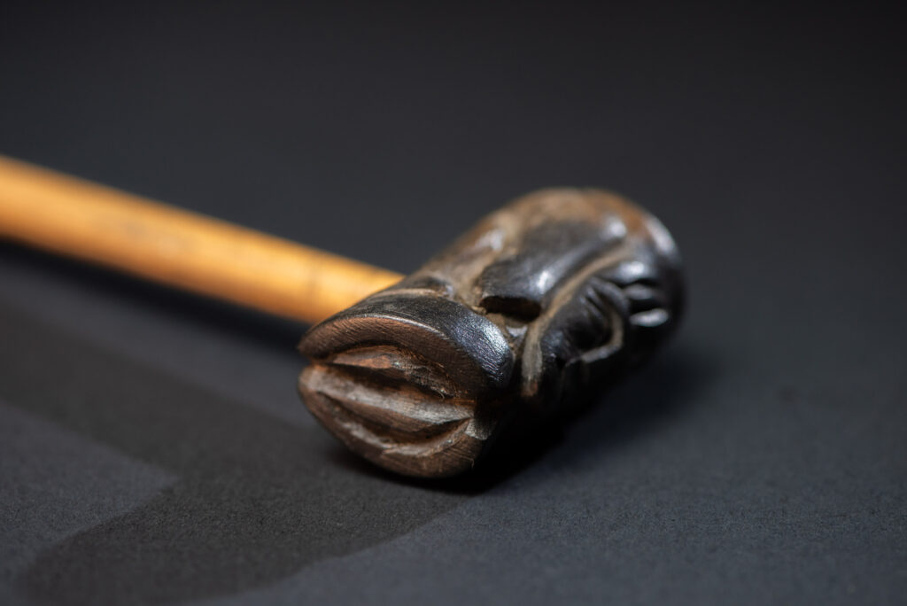 Very fine pipe made of precious wood from the Paiwan tribe, carved with human faces representing a Paiwan warrior and a stylised deer. The bottom is carved in a deer hoof shape.
