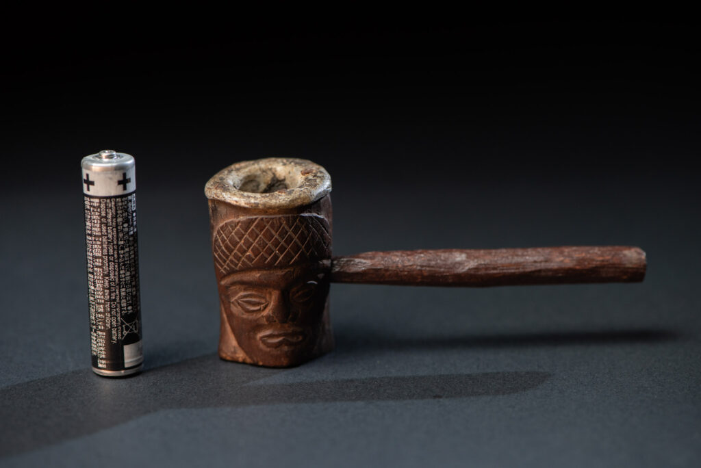 Very fine pipe from the Paiwan tribe, carved on both sides with human faces representing Paiwan warriors. The interior of the bowl is lined with aluminum.