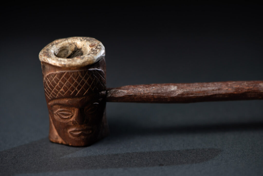 Very fine pipe from the Paiwan tribe, carved on both sides with human faces representing Paiwan warriors. The interior of the bowl is lined with aluminum.