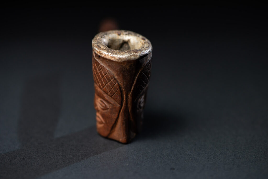 Very fine pipe from the Paiwan tribe, carved on both sides with human faces representing Paiwan warriors. The interior of the bowl is lined with aluminum.