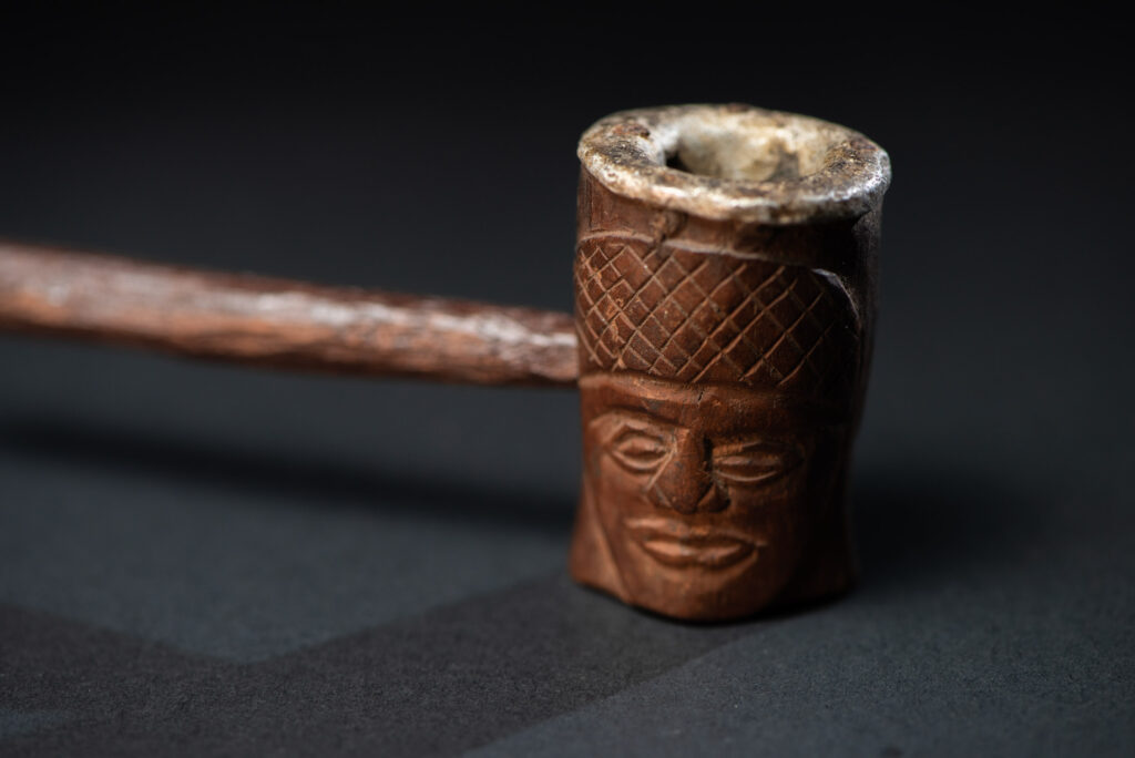 Very fine pipe from the Paiwan tribe, carved on both sides with human faces representing Paiwan warriors. The interior of the bowl is lined with aluminum.