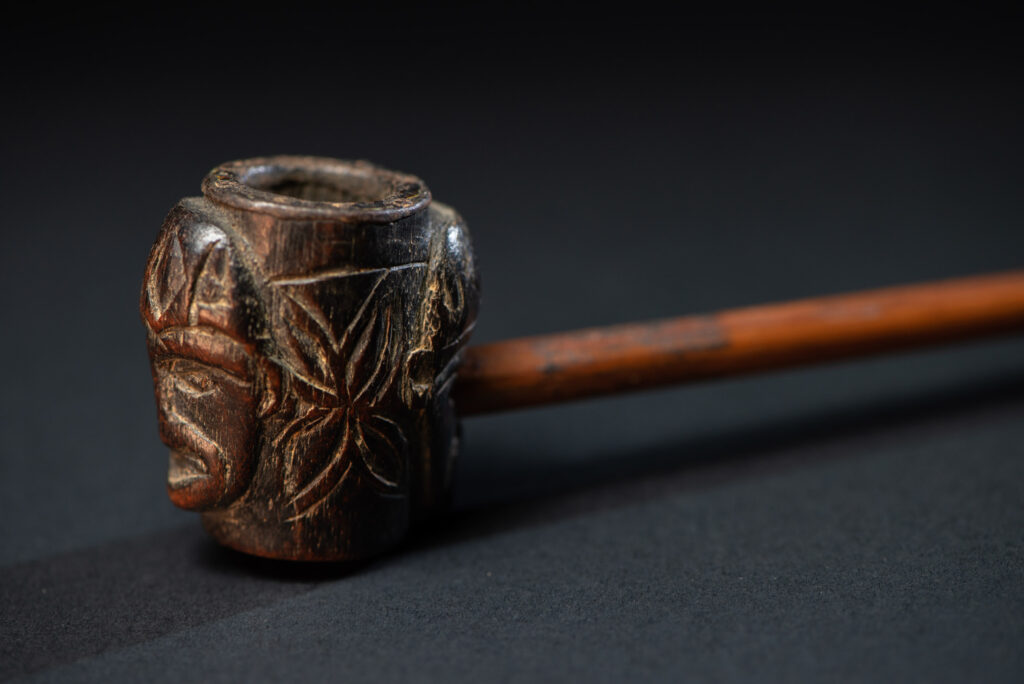 Very ancient fine pipe made of precious wood from the Paiwan tribe, carved with human faces representing a Paiwan warriors on the front and the back.