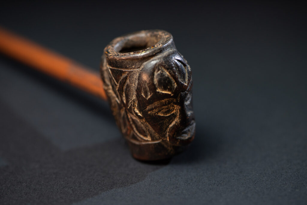 Very ancient fine pipe made of precious wood from the Paiwan tribe, carved with human faces representing a Paiwan warriors on the front and the back.