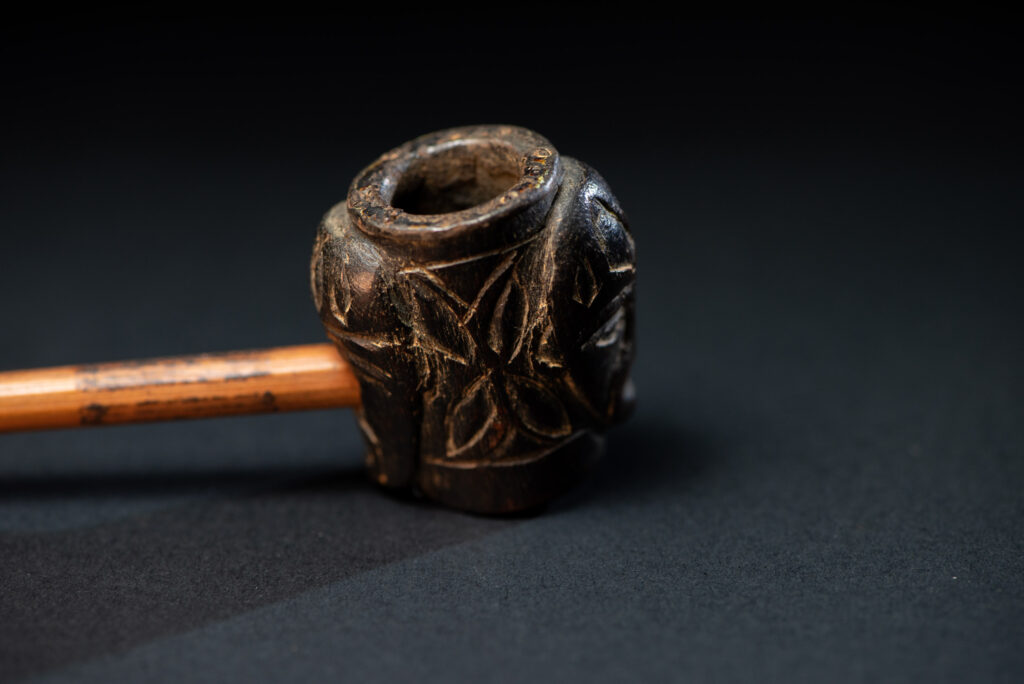 Very ancient fine pipe made of precious wood from the Paiwan tribe, carved with human faces representing a Paiwan warriors on the front and the back.