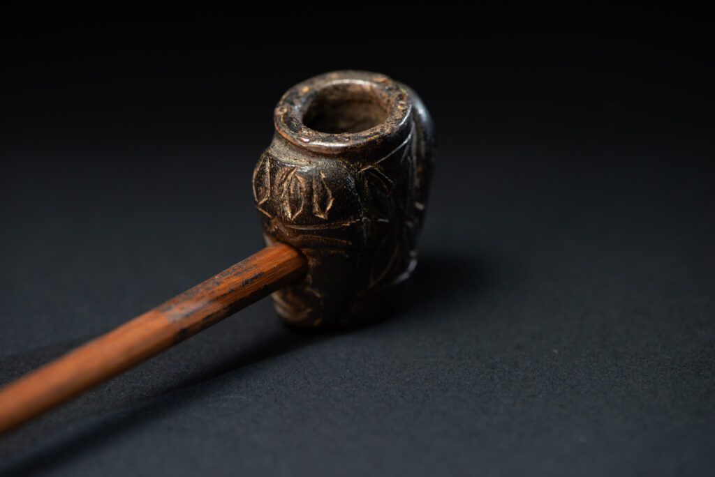 Very ancient fine pipe made of precious wood from the Paiwan tribe, carved with human faces representing a Paiwan warriors on the front and the back.