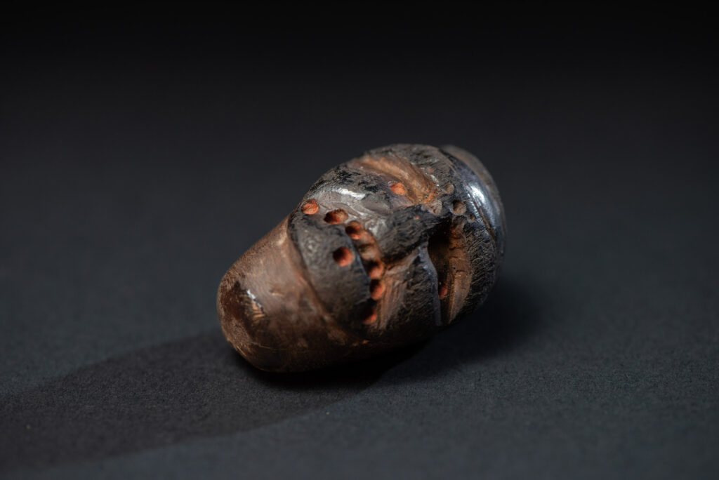Paiwan tribe pipe bowl carved with a human face.