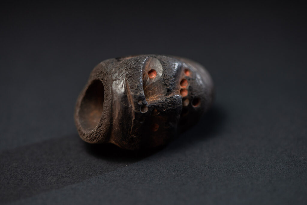 Paiwan tribe pipe bowl carved with a human face.