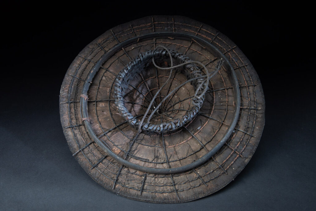 This ancient hat from the Yami- Tao tribes, orchid Island, Taiwan was worn by the female for work in the fields It is named “Varogot”. It is done with coconut palm bark, rotaing, aluminium and feathers for the top decoration..