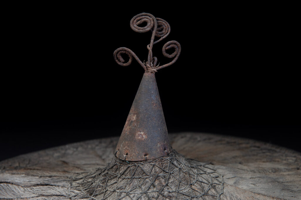 This ancient hat from the Yami- Tao tribes, orchid Island, Taiwan was worn by the female for work in the fields It is named “Varogot”. It is done with coconut palm bark, rotaing, aluminium and iron for the top decoration..