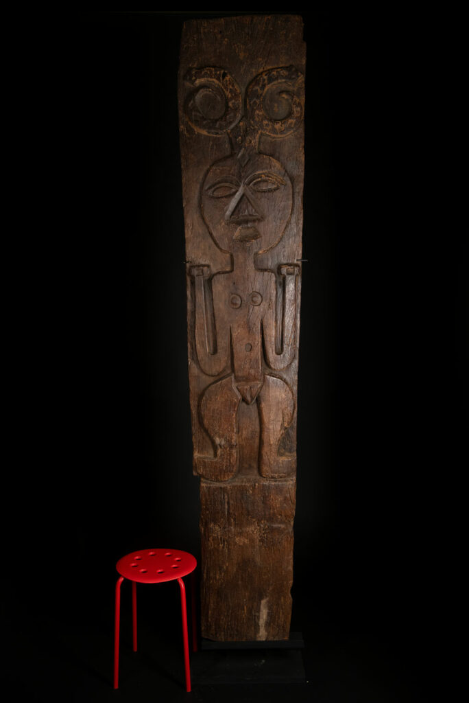 Very beautiful and massive ancestral panel from the Paiwan tribe, dating from the 19th century, carved with a nude female ancestor wearing a headdress formed by two intertwined snakes facing away from each other. A truly remarkable piece.