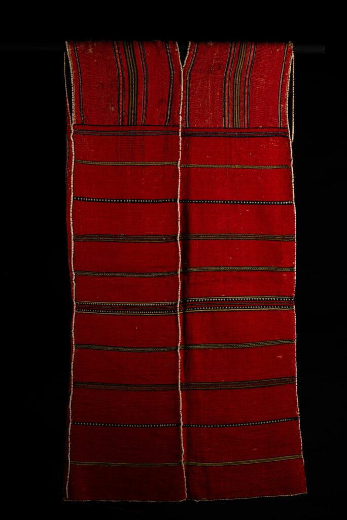 19 century Long men's jacket from the Atayal tribe, entirely woven in red with black and white stripes, and adorned with bone beads along the edges.