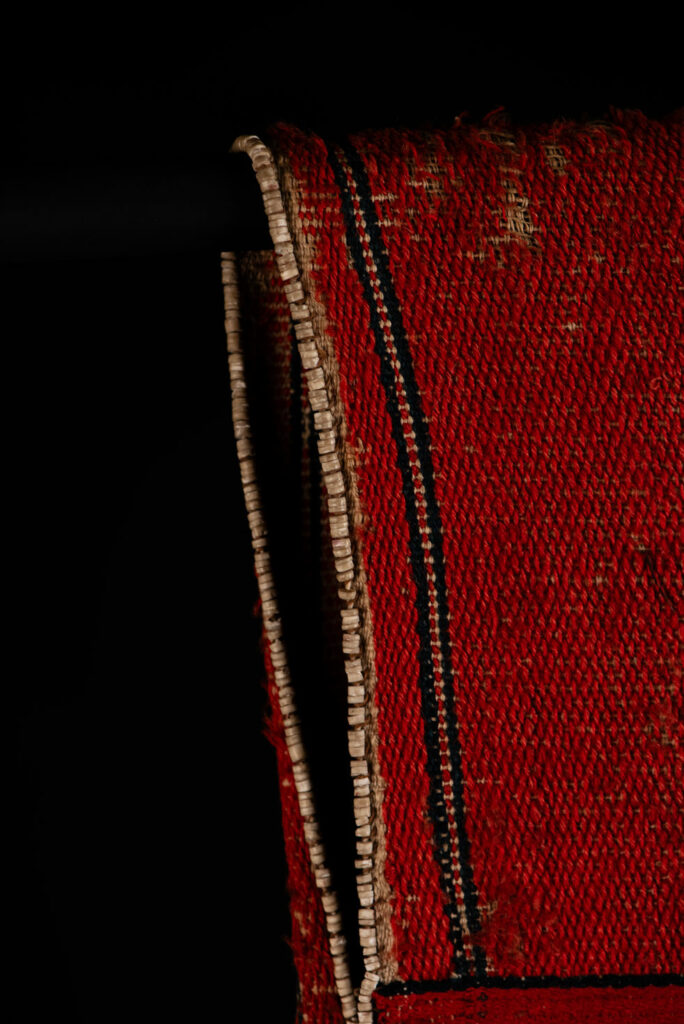 19 century Long men's jacket from the Atayal tribe, entirely woven in red with black and white stripes, and adorned with bone beads along the edges.