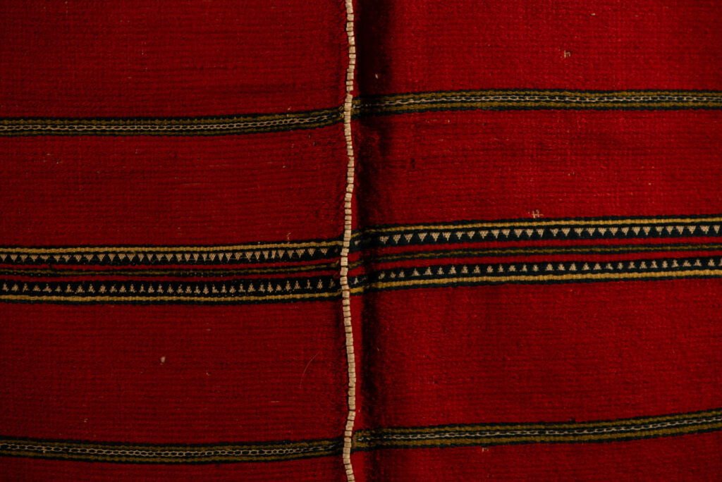 19 century Long men's jacket from the Atayal tribe, entirely woven in red with black and white stripes, and adorned with bone beads along the edges.