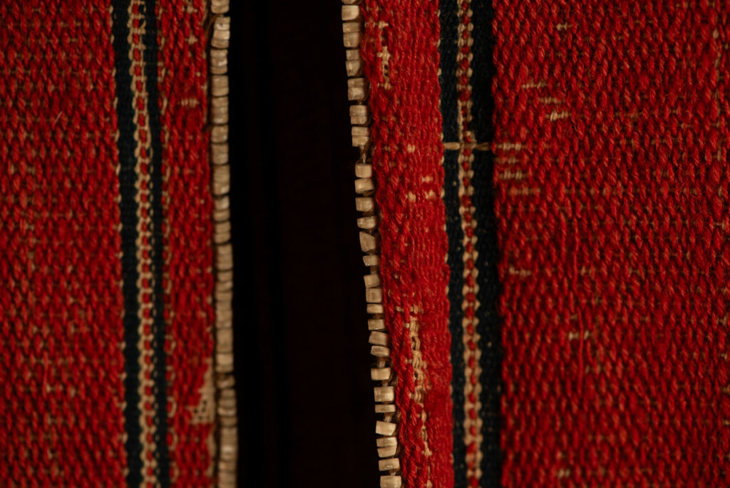 19 century Long men's jacket from the Atayal tribe, entirely woven in red with black and white stripes, and adorned with bone beads along the edges.beads along the edges.