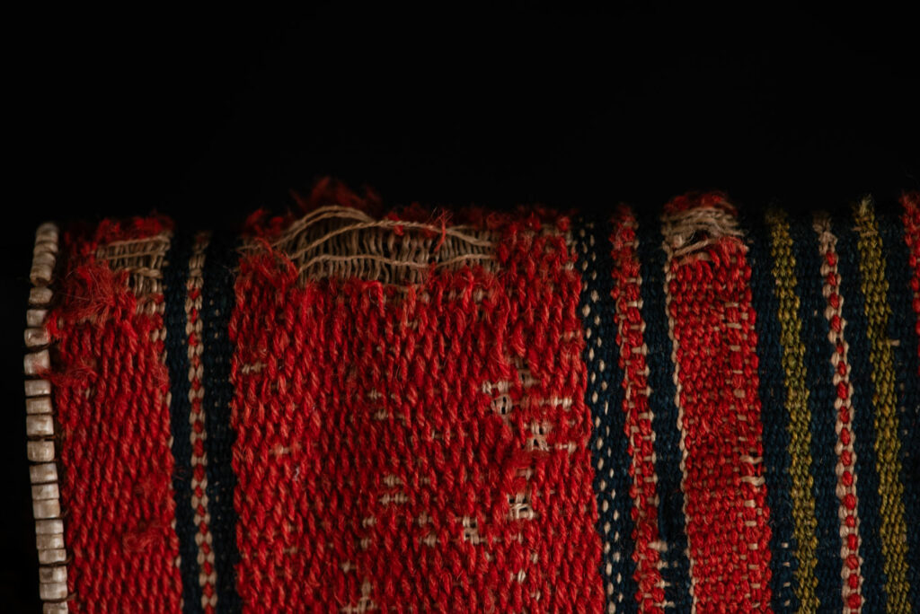 19 century Long men's jacket from the Atayal tribe, entirely woven in red with black and white stripes, and adorned with bone beads along the edges.