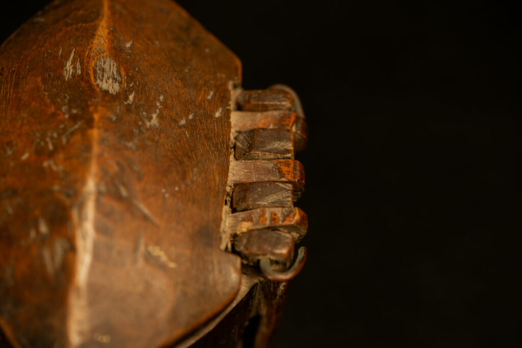 Wooden belt snuffbox from the Pingpu tribes, decorated with an engraving of a Chinese sage. It features a hinged lid carved from a single piece of wood and a section designed for attachment to the belt.