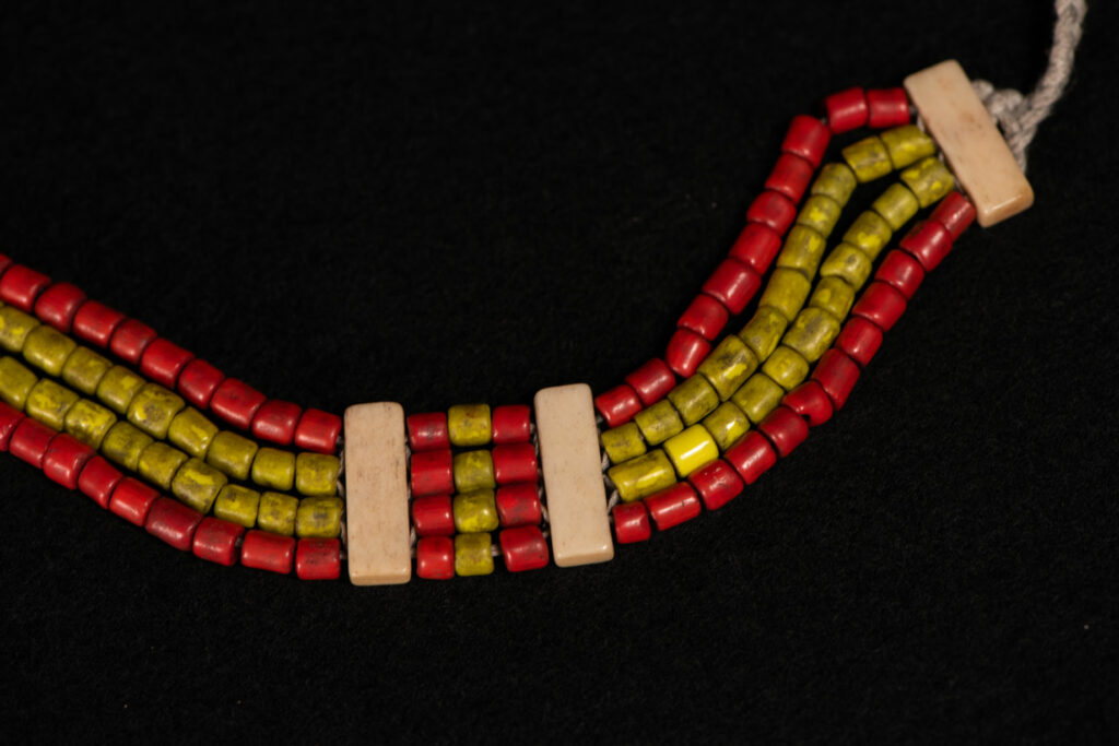 Bracelet from the Atayal tribe, made of yellow and red beads separated by polished bone bars, strung on a cord.
