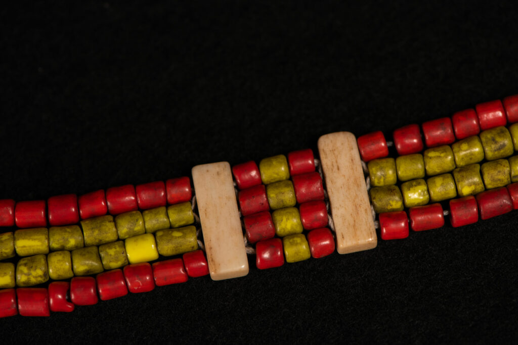 Bracelet from the Atayal tribe, made of yellow and red beads separated by polished bone bars, strung on a cord.