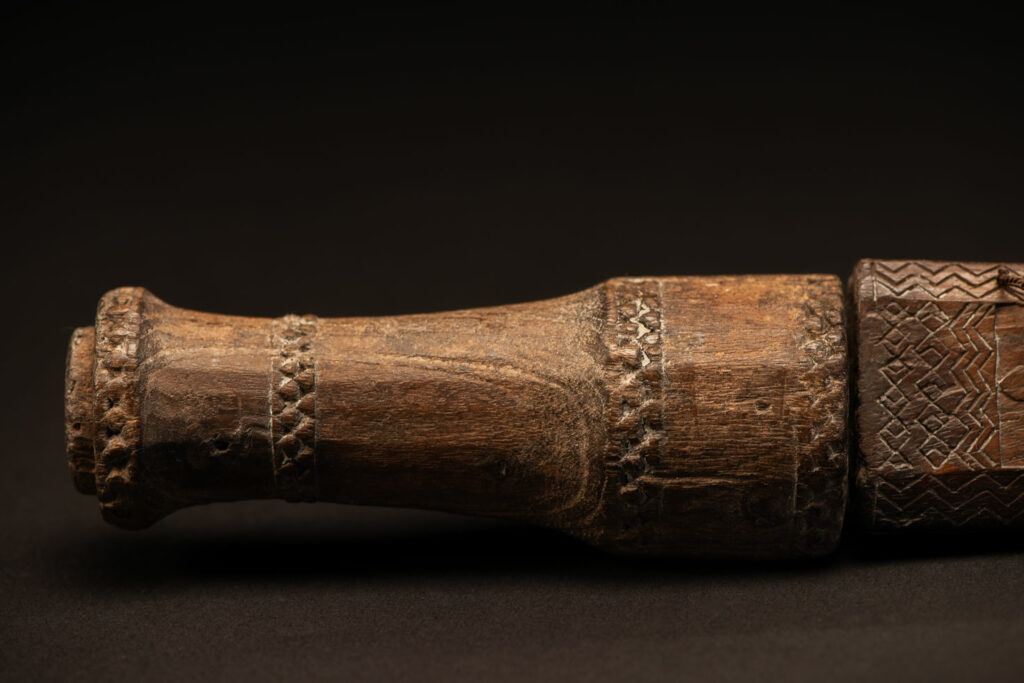 ‘Ipagan’ Knife and its sheath from the Yami (Tao) tribe. A fine example of the “Ipagan”, a short sword used to exorcise evil spirits but also to harvest. This sword, shorter than the Pararowai model, is notable for having both its handle and sheath carved with wave patterns, triangles, and the figure of the god Magamaog.