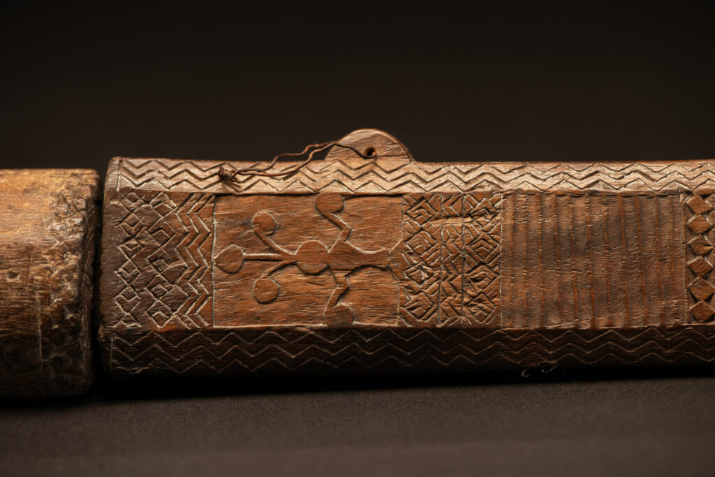 ‘Ipagan’ Knife and its sheath from the Yami (Tao) tribe. A fine example of the “Ipagan”, a short sword used to exorcise evil spirits but also to harvest. This sword, shorter than the Pararowai model, is notable for having both its handle and sheath carved with wave patterns, triangles, and the figure of the god Magamaog.
