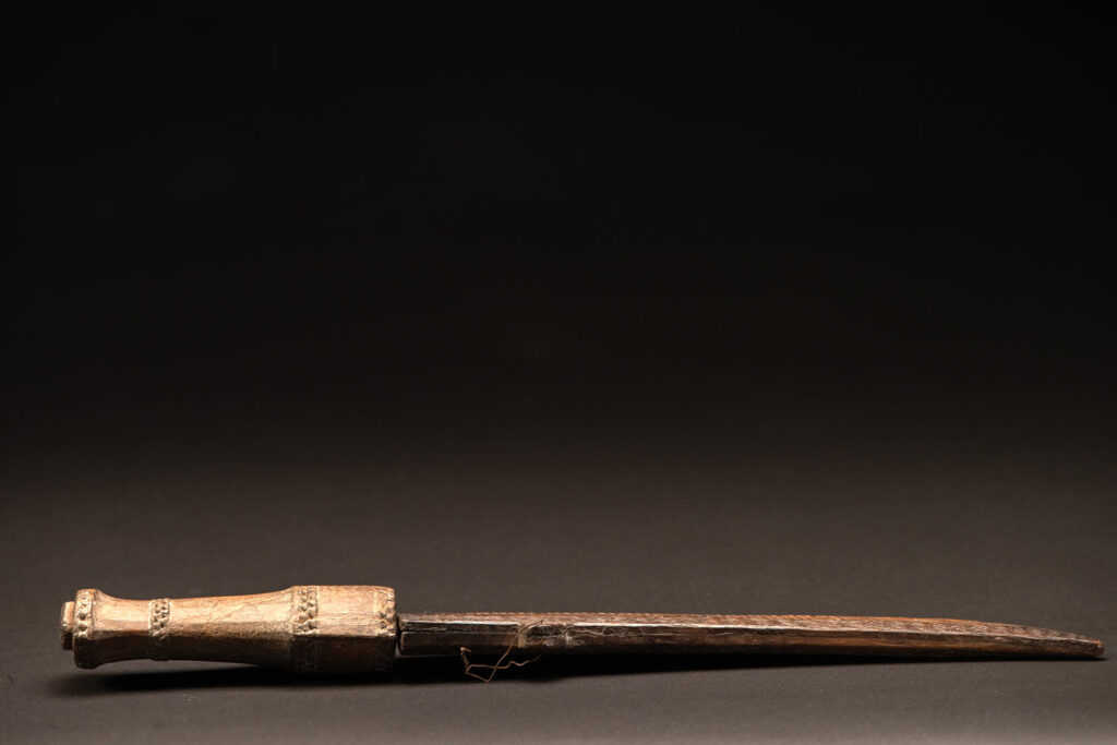 ‘Ipagan’ Knife and its sheath from the Yami (Tao) tribe. A fine example of the “Ipagan”, a short sword used to exorcise evil spirits but also to harvest. This sword, shorter than the Pararowai model, is notable for having both its handle and sheath carved with wave patterns, triangles, and the figure of the god Magamaog.