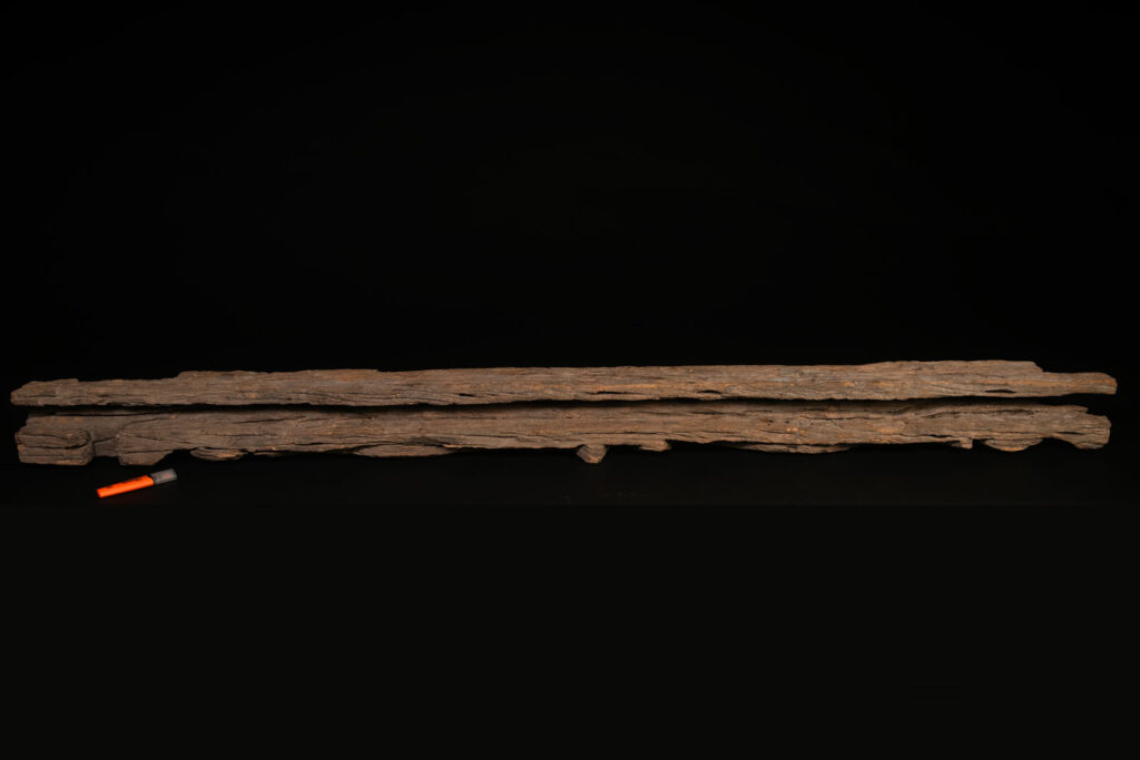 19th-century door lintel from the Paiwan tribe, carved with a pair of snakes facing each other and two human faces on either side. This Paiwan panel is heavily eroded and was probably placed above the entrance, exposed to the elements.