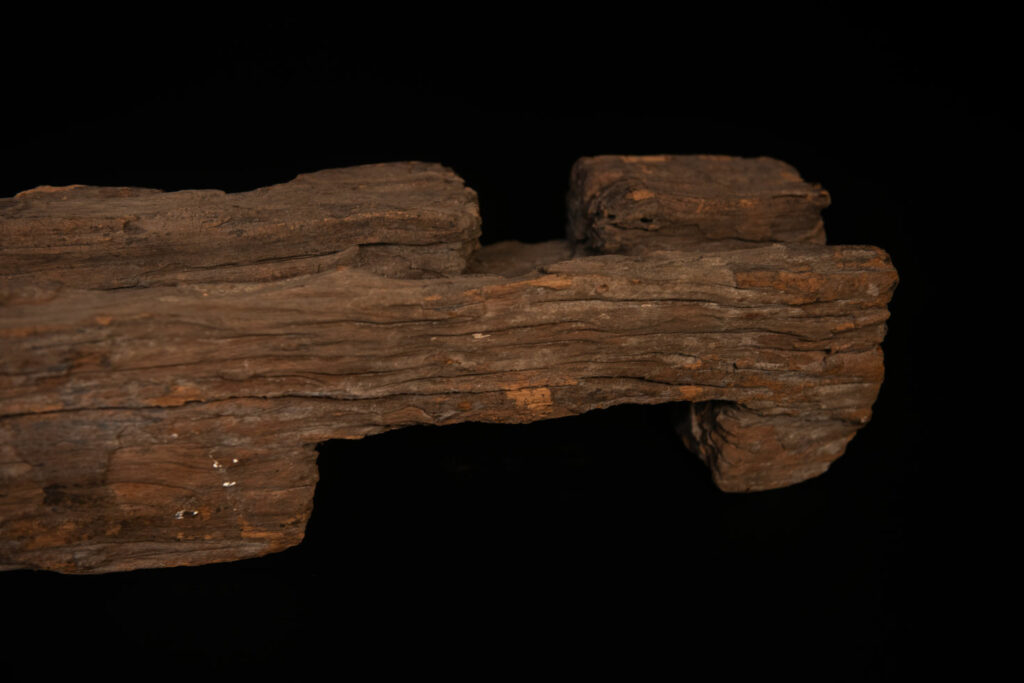 19th-century door lintel from the Paiwan tribe, carved with a pair of snakes facing each other and two human faces on either side. This Paiwan panel is heavily eroded and was probably placed above the entrance, exposed to the elements.