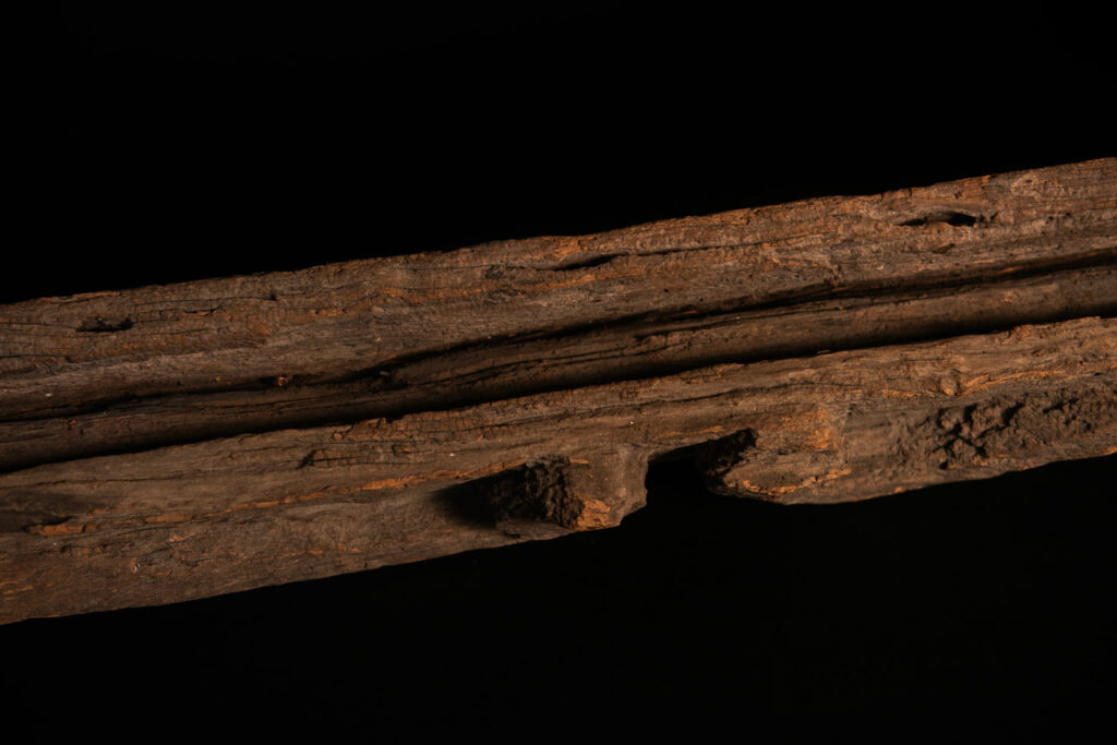 19th-century door lintel from the Paiwan tribe, carved with a pair of snakes facing each other and two human faces on either side. This Paiwan panel is heavily eroded and was probably placed above the entrance, exposed to the elements.