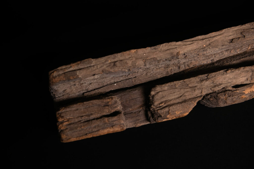 19th-century door lintel from the Paiwan tribe, carved with a pair of snakes facing each other and two human faces on either side. This Paiwan panel is heavily eroded and was probably placed above the entrance, exposed to the elements.