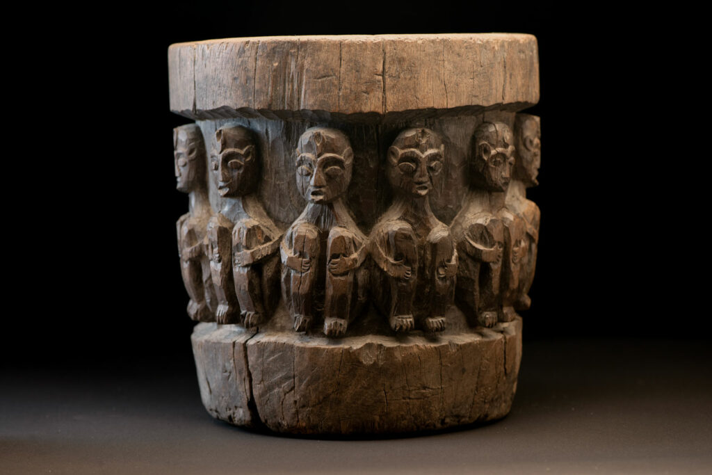 Small ancient mortar from the Paiwan tribe, richly carved around its circumference with a chain of crouching Paiwan figures.