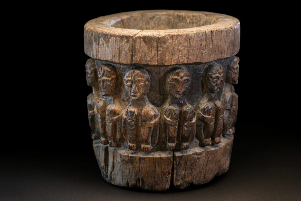 Small ancient mortar from the Paiwan tribe, richly carved around its circumference with a chain of crouching Paiwan figures.