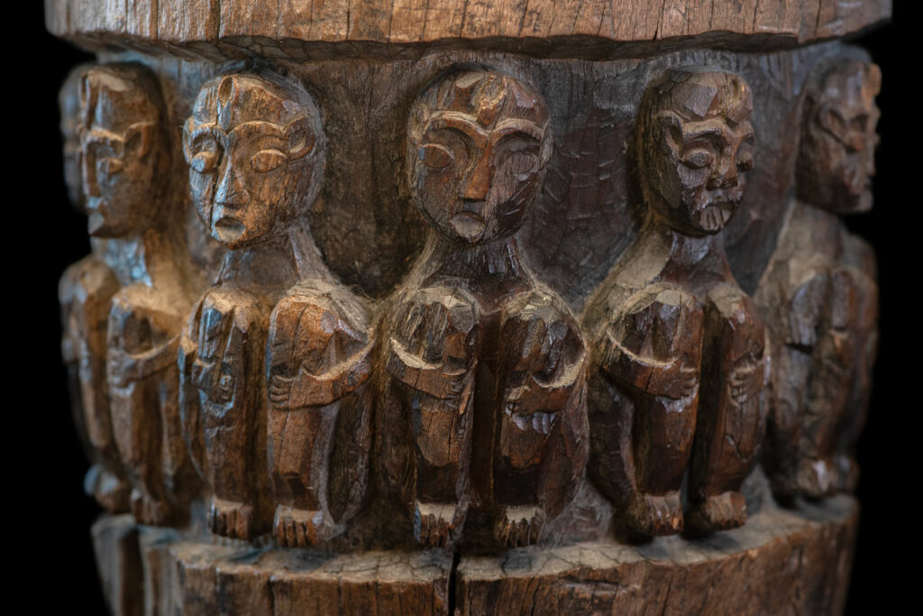 Small ancient mortar from the Paiwan tribe, richly carved around its circumference with a chain of crouching Paiwan figures.