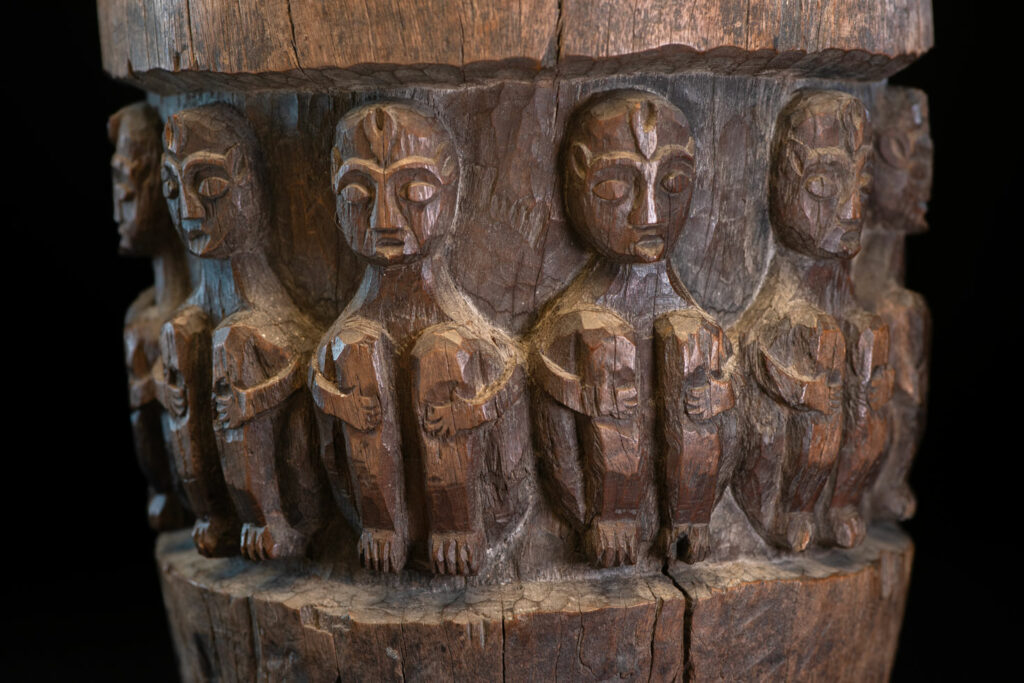 Small ancient mortar from the Paiwan tribe, richly carved around its circumference with a chain of crouching Paiwan figures.
