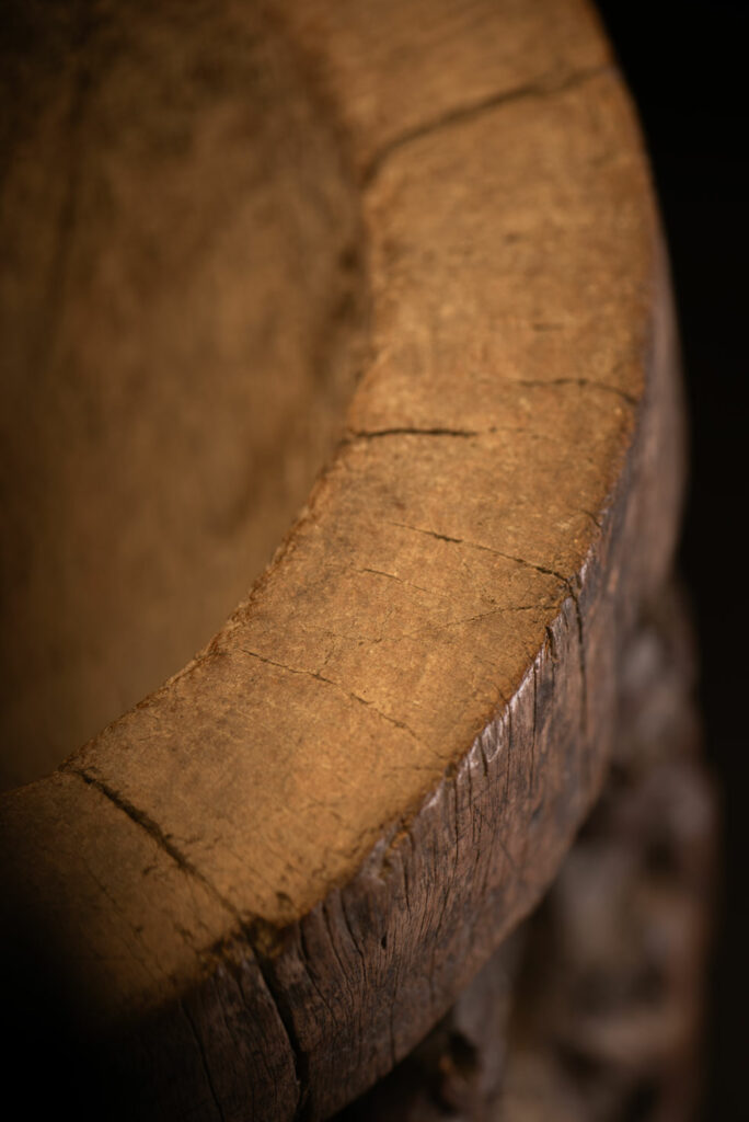 Small ancient mortar from the Paiwan tribe, richly carved around its circumference with a chain of crouching Paiwan figures.