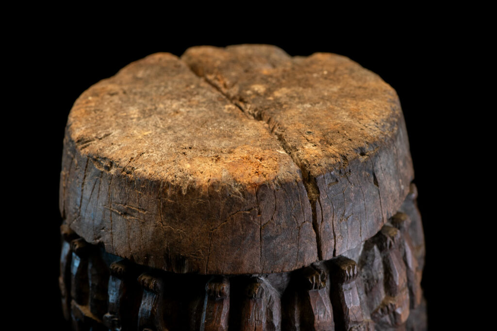 Small ancient mortar from the Paiwan tribe, richly carved around its circumference with a chain of crouching Paiwan figures.