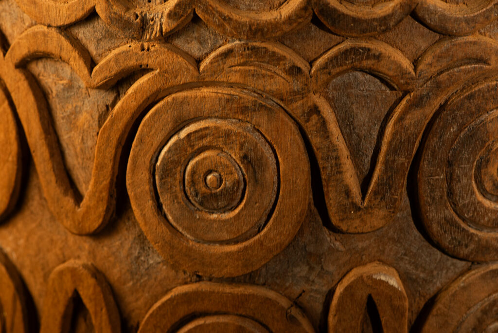 Ancient granary chest from the Paiwan tribe, used to store millet grains. Richly carved with sacred snakes, human heads, circular motifs, and anthropomorphic figures.