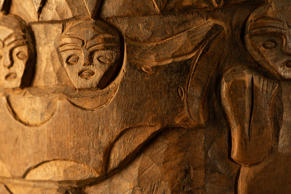 Ancient granary chest from the Paiwan tribe, used to store millet grains. Richly carved with sacred snakes, human heads, circular motifs, and anthropomorphic figures.