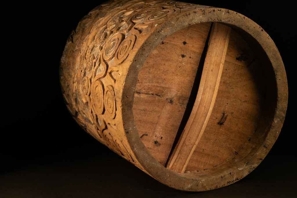 Ancient granary chest from the Paiwan tribe, used to store millet grains. Richly carved with sacred snakes, human heads, circular motifs, and anthropomorphic figures.