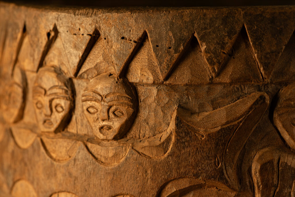 Ancient granary chest from the Paiwan tribe, used to store millet grains. Richly carved with sacred snakes, human heads, circular motifs, and anthropomorphic figures.