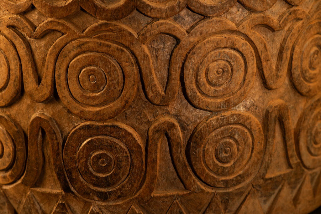 Ancient granary chest from the Paiwan tribe, used to store millet grains. Richly carved with sacred snakes, human heads, circular motifs, and anthropomorphic figures.