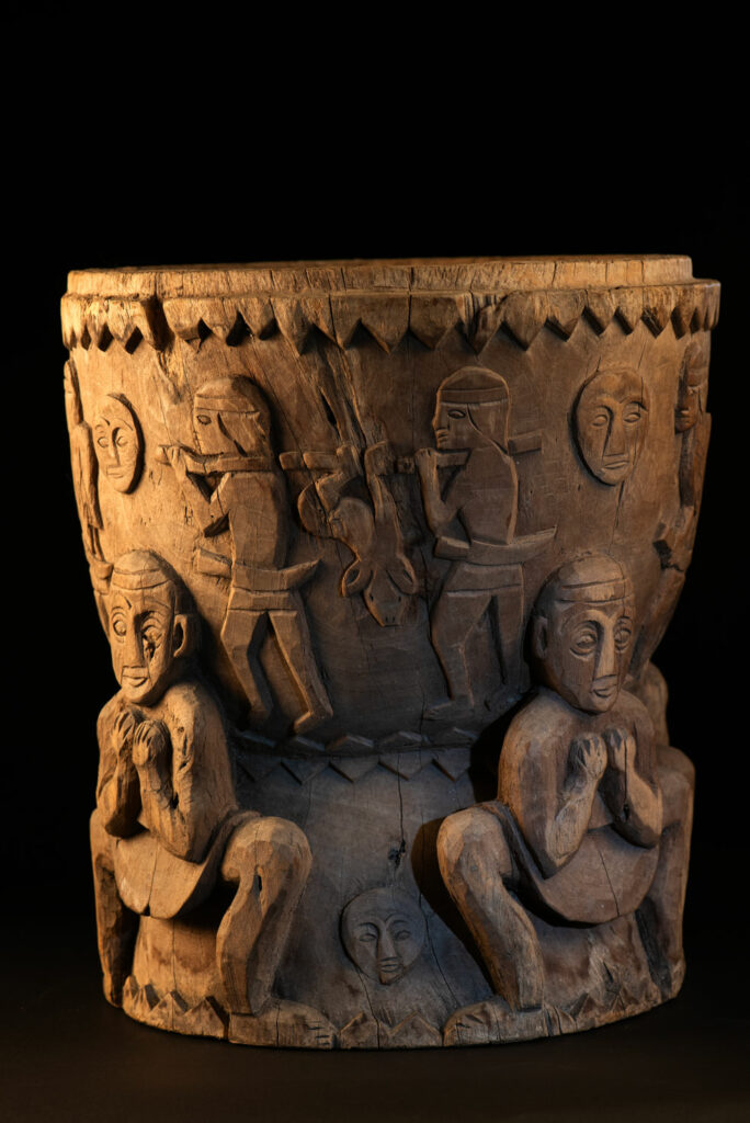 Ancient mortar from the Troukou (Pingpu) tribe, carved with crouching figures, human heads, and hunters carrying game or hunting with bows.