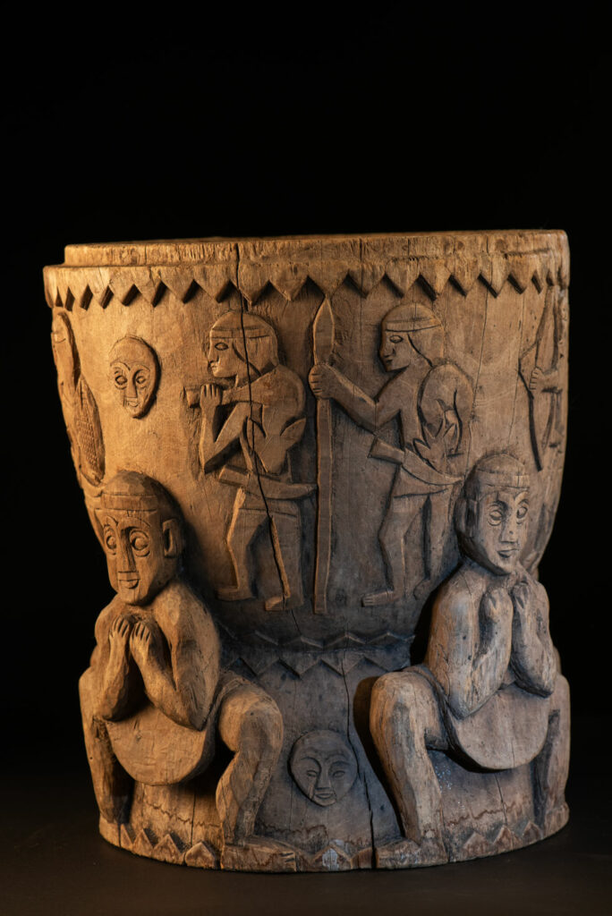 Ancient mortar from the Troukou (Pingpu) tribe, carved with crouching figures, human heads, and hunters carrying game or hunting with bows.
