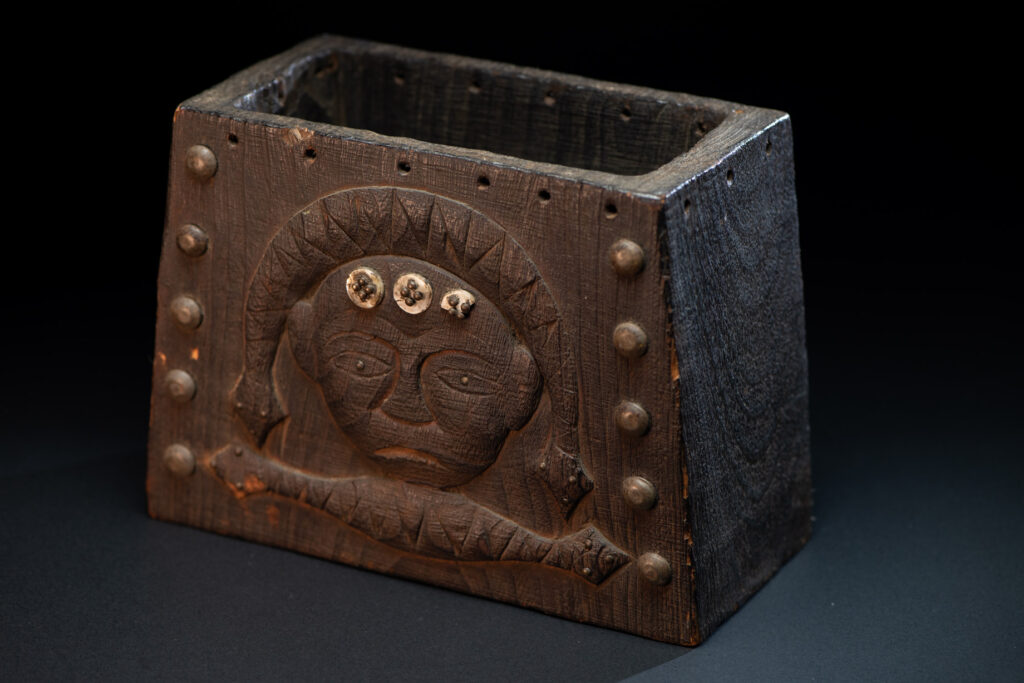 Paiwan tribe shaman box carved with a human head Wearing a two-headed snake as a headdress and other one on his neck. The edge of the shaman's box is studded with upholstery nails.