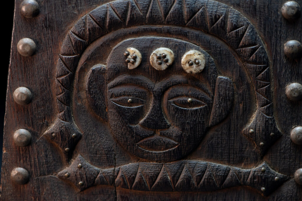 Paiwan tribe shaman box carved with a human head Wearing a two-headed snake as a headdress and other one on his neck. The edge of the shaman's box is studded with upholstery nails.